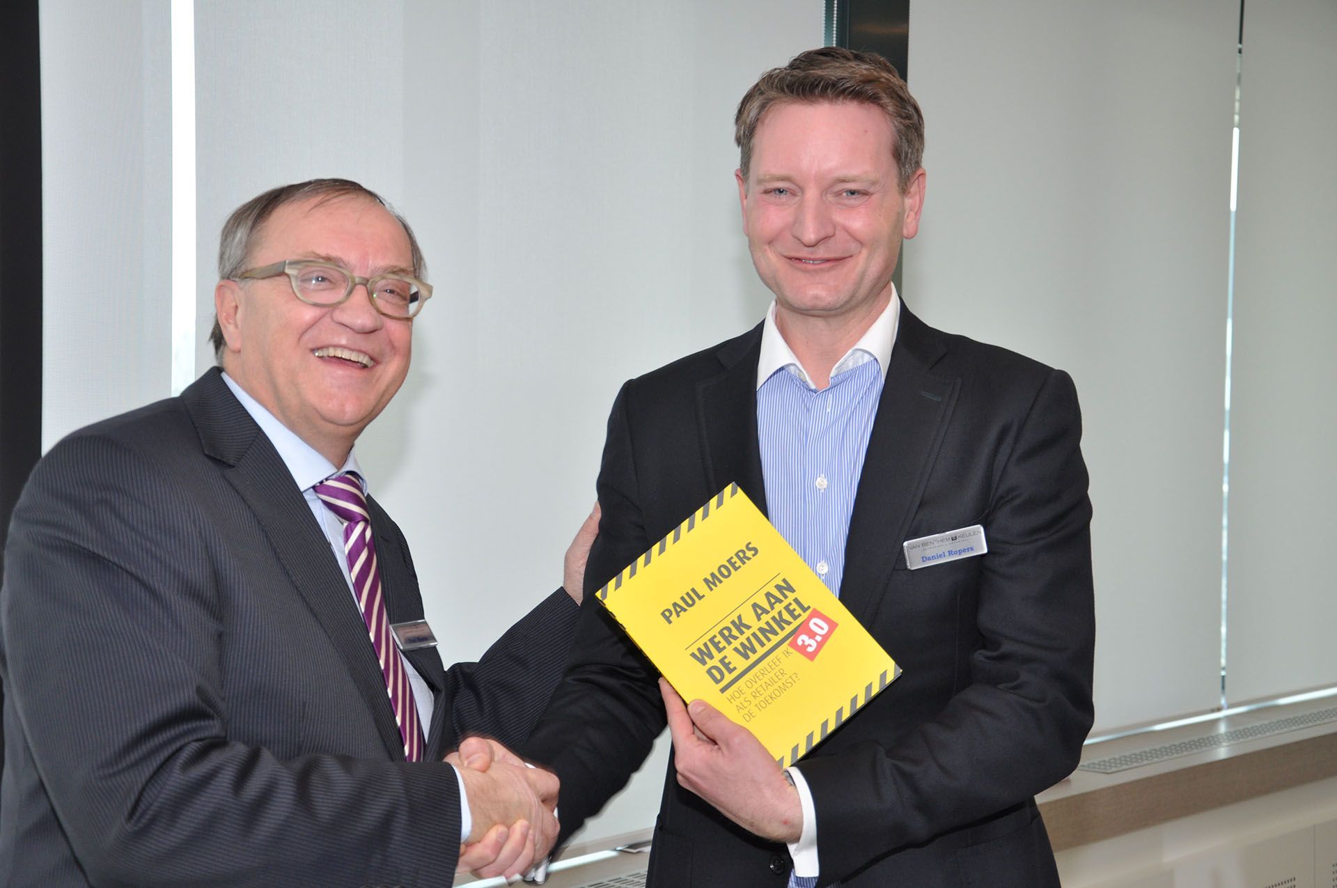 Paul Moers overhandigt boek aan Daniel Ropers van Bol.com bij van Benthem en Keulen in Utrecht